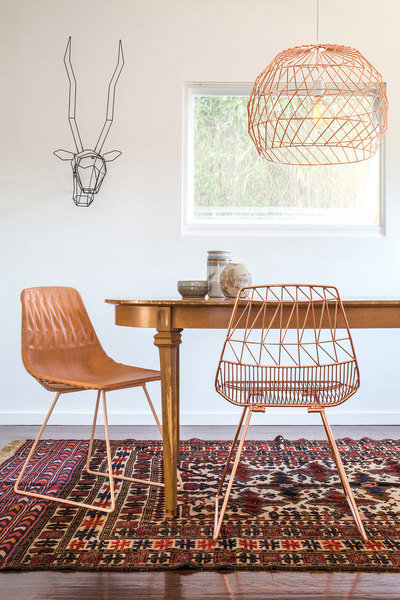 Galvanized iron woven wire chairs, pendant lighting and a gazelle “trophy” all designed by Bend Goods