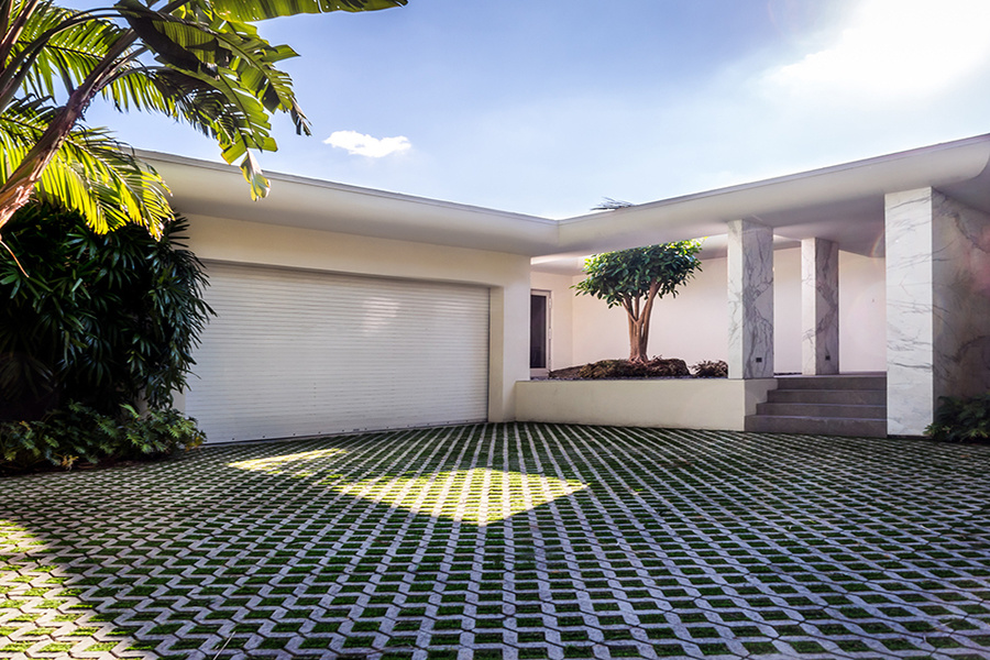 The house sits on a 12,150-square-foot lot. The driveway features hand-placed squares of artificial g