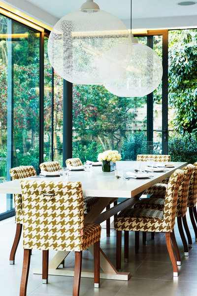 A glass-enclosed West London terrace designed by Karen Howes lets the surrounding landscaping take ce