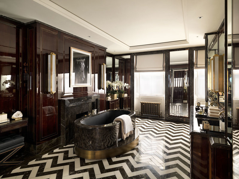 Black-and-white herringbone-patterned stone flooring lends refined elegance to a stately bathroom des