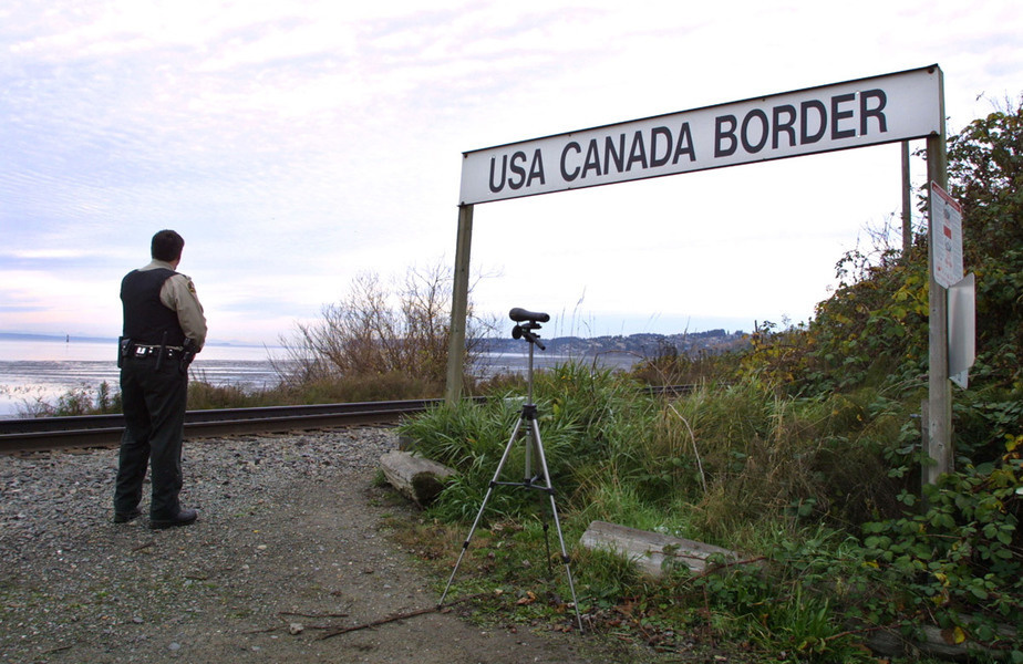 A Canadian customs and fisheries officer watches over the U.S.-Canada border.