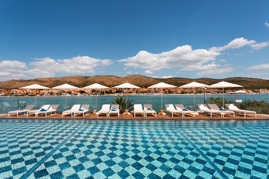 Designed by Saar Zafrir, the pool area of Brown Beach House Croatia combines a wooden deck and black-